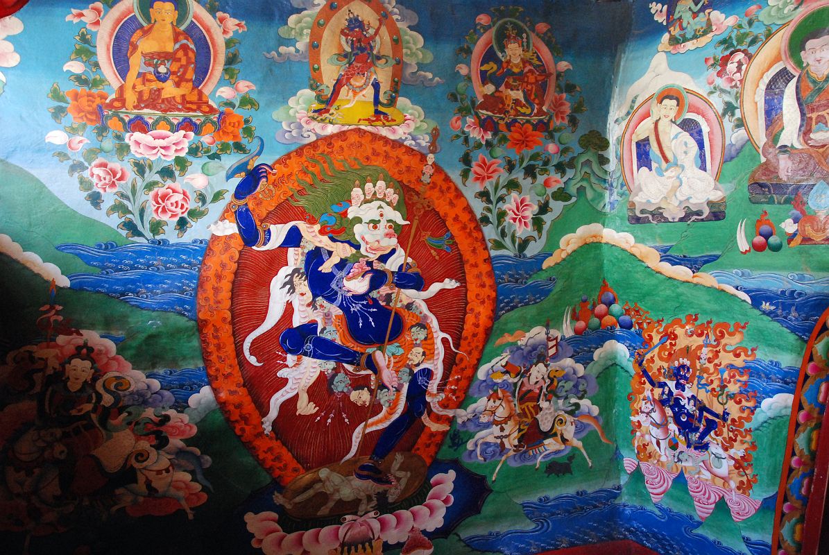 33 Paintings Outside Cave Of The Female Yak Horns Dirapuk Gompa Lion-Faced Goddess Dakini Simhamukha Senge Dongma, Padmasambhava Guru Rinpoche, Milarepa, Marpa, Shangpa Karpo, Shri Devi Palden Lhamo At the back of the Dirapuk Gompa is the cave of the female yak horns. Murals surround the entrance including the lion-faced-goddess Dakini Simhamukha (Tib. Senge Dongma). The face is a white lion with three round orange eyes blazing fiercely with a gaping mouth, and hair flowing upward. The right hand holds upraised a curved knife to the sky, left a skullcup of blood to the heart, carrying a khatvanga staff tipped with a trident in the bend of the elbow supported against the shoulder. Above to the left is Buddha, then Chakrasamvara (Tib. Demchog) in yab-yum with Vajrayogini (Tib. Dorje Phagmo), Padmasambhava (Tib. Guru Rinpoche), Milarepa holding his hand to his ear, Milarepas teacher Marpa, At the lower left is the worldly protector Shangpa Karpo, white, with one face and two hands holding a lance in the right and a bowl of jewels in the left; riding a white horse. Im not sure who the figure is to the right of lion-faced goddess. He is white with one face and two hands holding upraised in the right a riding whip and in the left a spear with a red banner. The final figure to the lower right is Shri Devi (Tib. Palden Lhamo), dark blue in colour, riding side saddle on a white mule with a sword in her upper right, a skullcup in her lower right, and khatvanga in her first right hand and another staff in her far right hand. She has a sun and moon disc at her waist.